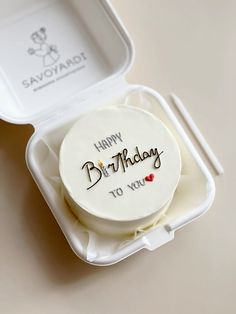 a happy birthday cake in a plastic container with the lid open to show it's frosting