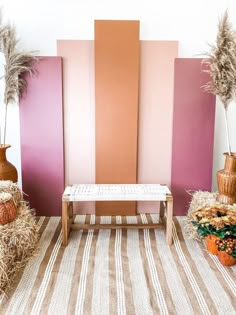 a bench sitting in front of a wall with pink and orange panels on the walls