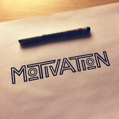 the word motivation written on a piece of paper next to a marker with a pen