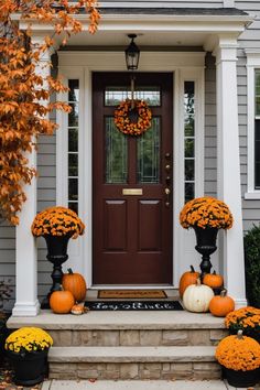 front porch decorated for fall with pumpkins and mumbers