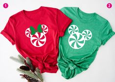 two red and green tshirts with mickey mouse ears on them, next to pine cones