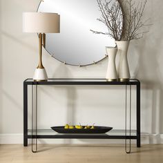 a mirror and vase on a table with lemons