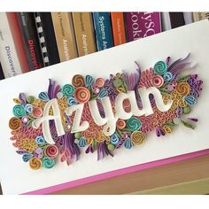 a greeting card with the word azura surrounded by colorful paper flowers and spirals