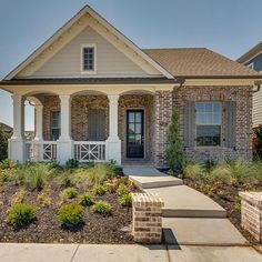 a brick house with white trim and two front porches is shown in the foreground