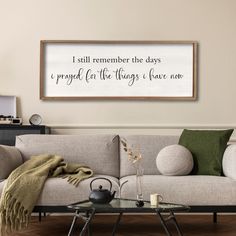 a living room with a couch, coffee table and large framed sign on the wall