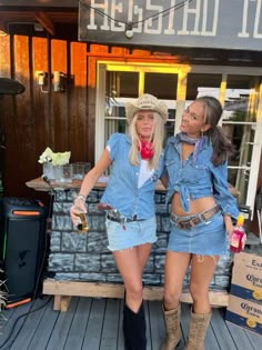 two women in cowboy outfits standing on a porch