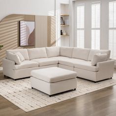 a living room with a white sectional couch and footstool in front of a large window