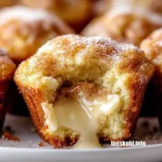 a close up of a muffin on a plate with powdered sugar and icing