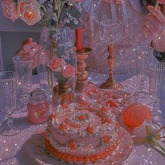 a woman sitting at a table in front of a cake with candles and flowers on it