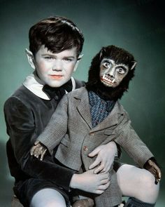 a young boy sitting next to a creepy doll