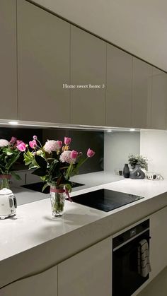 flowers in vases sit on the counter top next to an appliance and oven