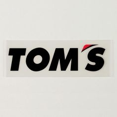 a sticker with the word tom's on it in black and red letters