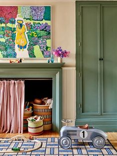 a toy car sitting on top of a rug in front of a fireplace