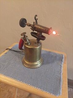 an old fashioned machine with a red light on it's head sitting on top of a table