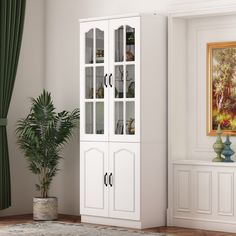 a white cabinet sitting next to a potted plant in a room with green curtains