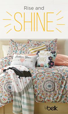 an image of a bed with pillows and blankets on it that say rise and shine