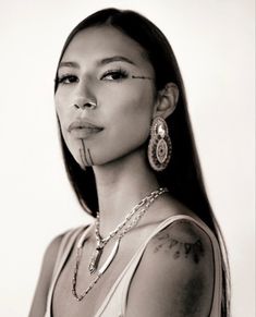 a black and white photo of a woman with piercings on her nose, wearing a tank top