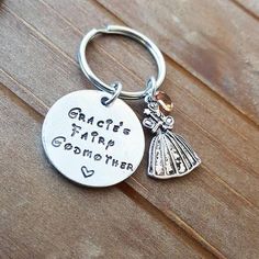 a metal keychain with a charm on it that says, grace's fairy godmoter