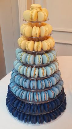 a stack of blue and yellow macaroons sitting on top of a white table