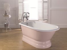 a bath tub sitting on top of a hard wood floor next to a white wall