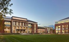 two large brick buildings sitting on top of a lush green field