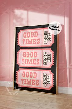 two pink and black movie tickets sitting on top of a wooden floor in front of a pink wall