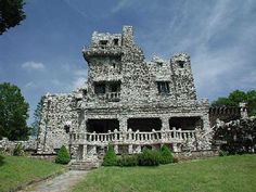 an old stone building sitting on top of a lush green field