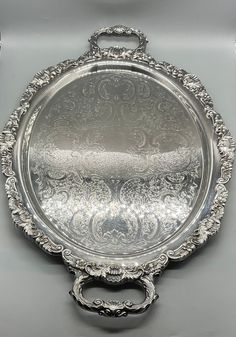 an ornate silver tray with handles on it