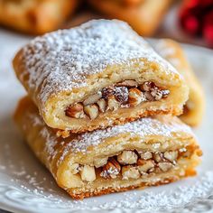 two pastries on a plate with powdered sugar