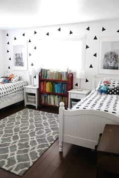 a bedroom with two twin beds and a bookcase in the corner on the far wall