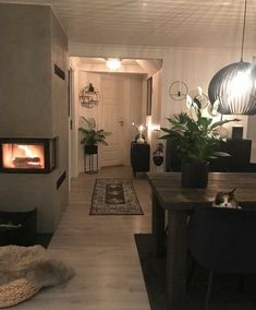 a living room filled with furniture and a fire place next to a dining room table