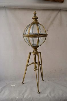 an antique brass tripod lamp with glass globes