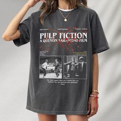 a woman wearing a black pulp fiction t - shirt with two pictures of the same character