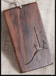 a wooden plaque with a cross on it sitting on top of a cloth covered surface