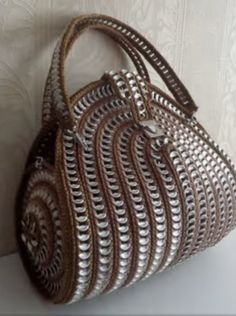 a brown and white purse sitting on top of a table next to a beige wall