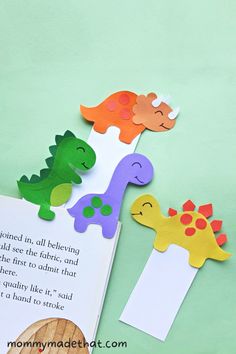 an open book with cut out dinosaurs on it