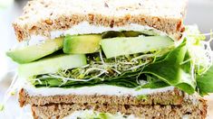 a sandwich with cucumber, lettuce and cheese