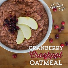 a bowl of oatmeal with apples and cranberries on the side