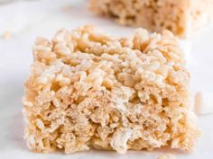 two pieces of rice krispy treats sitting on top of a white countertop next to each other