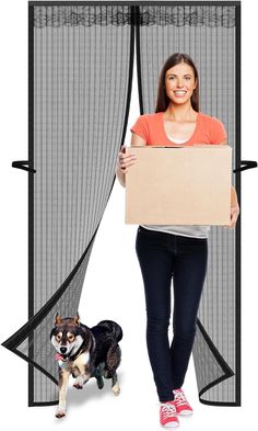 a woman holding a cardboard box with a dog standing in front of her behind the screen