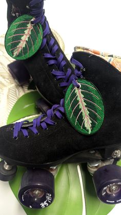 the skateboard is decorated with green leaves and purple laces