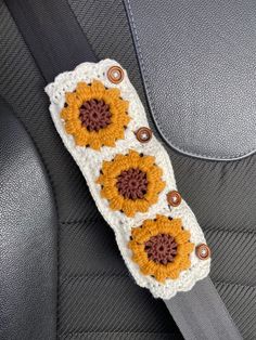 a crocheted sunflower is sitting on the back seat of a car