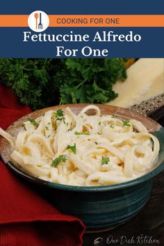 fettuccine alfredo in a bowl with parsley on the side