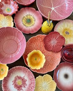 many different colored plates and vases are arranged in a pattern on the table top