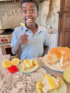 a person sitting at a table with plates of food and lemons in front of them