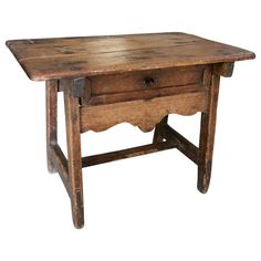 an old wooden table with one drawer on the top and two drawers at the bottom