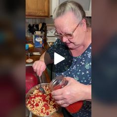 an older woman is cooking pasta in a pot