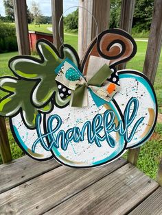 a wooden sign with the word grateful hanging from it's side on a porch