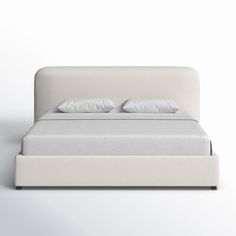 a white bed with two pillows on it