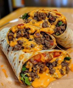 two burritos with meat and cheese on them